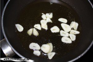 Salmón a la plancha con ajos y pimientos, freír los ajos