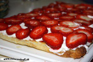 Hojaldre con nata y fresas, cubrir con las fresas cortadas