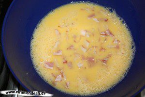 Tortilla de papas con bacon, batir los huevos y añadir el bacon