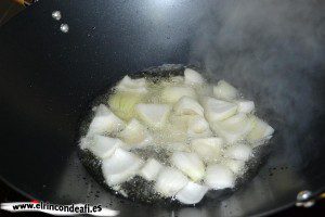 Verduras con salsa agridulce salteadas al wok, añadir cebolla en el aceite y salar