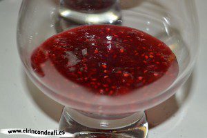 Crème brulée flambeada con lecho de mermelada de frambuesa, verter en las copas