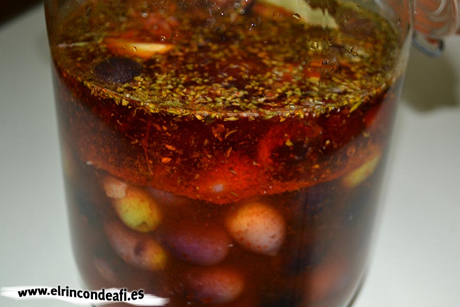 Aceitunas con mojo canario, añadir el aceite y cubrir el resto con agua