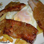 Secreto ibérico con huevos rotos y cebolla caramelizada