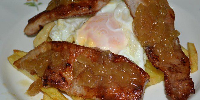 Secreto ibérico con huevos rotos y cebolla caramelizada