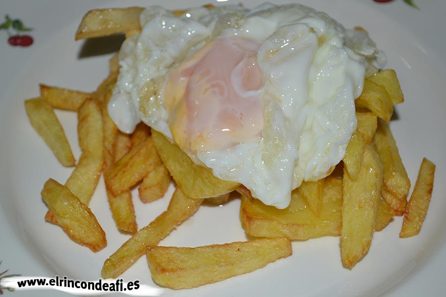 Secreto ibérico con huevos rotos y cebolla caramelizada, freír papas y poner encima un huevo frito