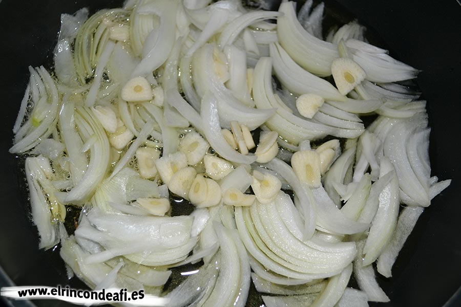 Cherne con pimientos y cebolla, añadirle los ajos laminados