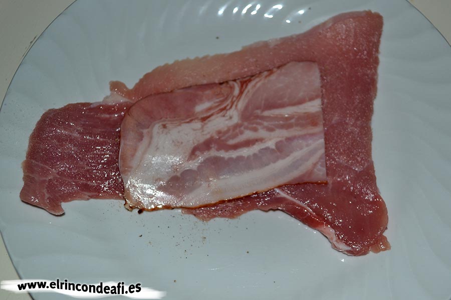 Enrolladitos de cerdo con bacon y queso, salpimentar y poner media loncha de bacon