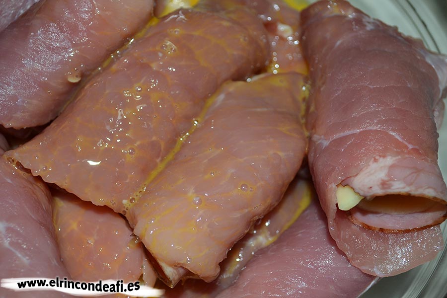 Enrolladitos de cerdo con bacon y queso, pasarlos por huevo batido