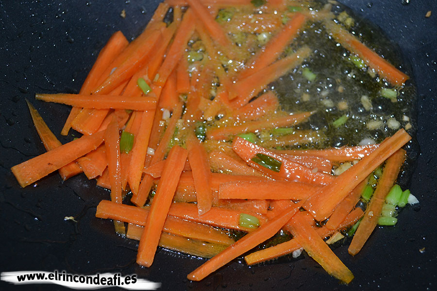 Tallarines con verduras, langostinos y cerdo al wok, añadir las zanahorias y los ajetes