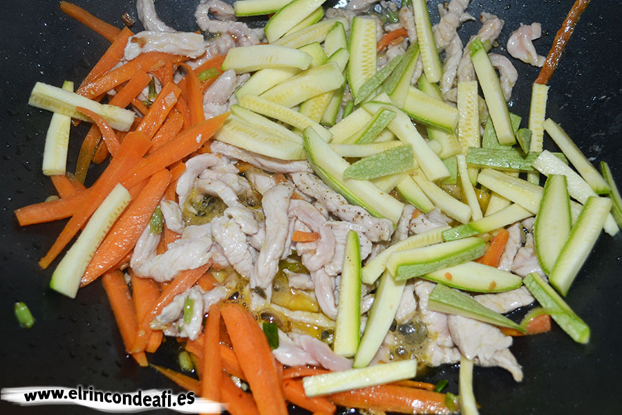 Tallarines con verduras, langostinos y cerdo al wok, añadir los calabacines