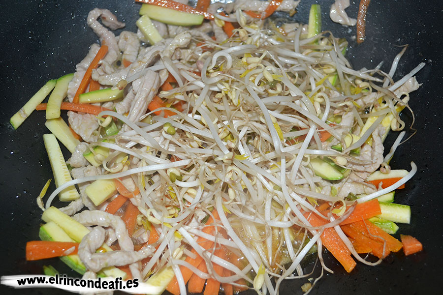 Tallarines con verduras, langostinos y cerdo al wok, añadir los brotes de soja
