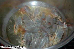 Arroz a la banda, poner las cabezas de los langostinos en un caldero con aceite