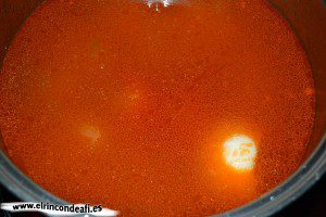 Arroz a la banda, cubrir con agua y añadir un tomate, una cebolla, un puerro y un pimiento