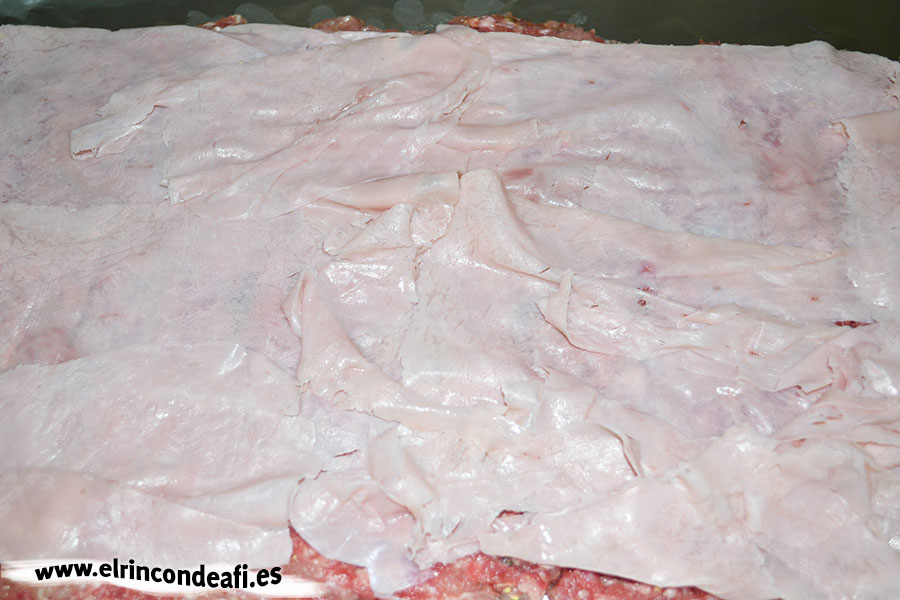 Enrollado de carne molida relleno de jamón y queso, colocar encima lonchas de jamón cocido