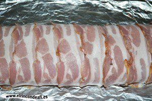 Enrollado de carne molida relleno de jamón y queso, enrollar y cubrir de lonchas de bacon