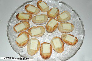 Tapa con jamón, queso brie y aceitunas, colocar una loncha de queso brie encima de cada rebanada