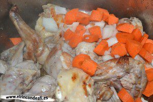 Arroz con conejo, añadir la cebolla y la zanahoria troceadas