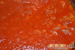 Macarrones con salsa de tomate y atún, añadir la salsa de tomate a la cebolla ya pochada en el mismo caldero