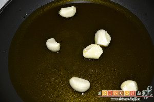 Bacalao al pil pil, dorar los ajos enteros en una sartén con abuntande aceite