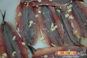Boquerones al limón, picar los ajos y echarlos sobre los boquerones