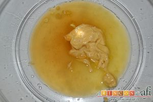 Ensalada variada con torreznos, cortar la naranja en gajos sobre un bol para aprovechar el jugo y añadir la mostaza y el vinagre