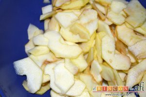 Bizcocho con manzanas, pelamos las manzanas, las cortamos en cuartos, las descorazonamos y las cortamos en láminas finas, y les añadimos el zumo del limón y el coñac