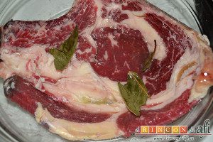 Chuletón a la vizcaína, en un bol ponemos a macerar el chuletón con el zumo del limón, un chorro de aceite de oliva y una hoja de laurel cortada en trozos
