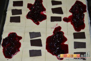 Empanadillas de cerezas y chocolate, ponemos confitura de cerezas en unos rectángulos y trozos de chocolate en otros