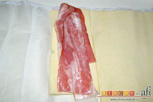 Aperitivo de hojaldre con salchichas o bacon, colocar dos tiras de bacon por rectángulo