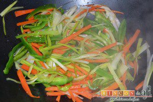 Noodles con lomo de cerdo, verduras y champiñones salteados al wok, añadir el pimiento y mover con cuchara de madera