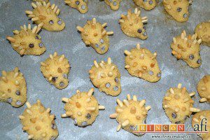 Erizos de panellets, dejar reposar la masa, formar ericitos sobre papel de horno, decorar con pepitas de chocolate y piñones