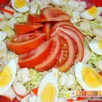 Ensalada con tomate, huevos, queso, col y palitos de cangrejo