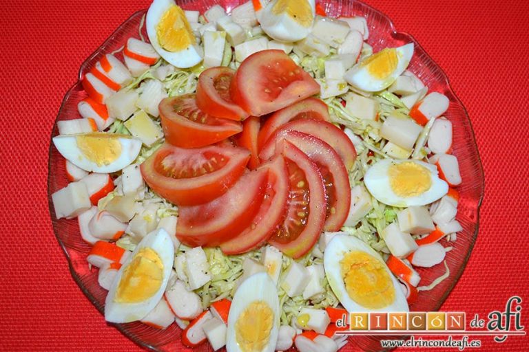 Ensalada con tomate, huevos, queso, col y palitos de cangrejo, sugerencia de presentación