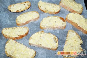 Pan de ajo gratinado, cortar en rodajas el pan y untarlo generosamente con la mantequilla