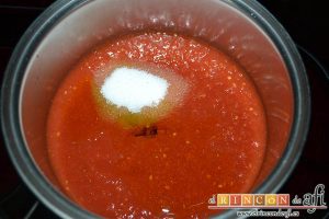 Pisto con bacalao y ajos tiernos, hacer la salsa de tomate poniendo en un caldero un poco de aceite y luego el tomate triturado y las dos cucharadas de azúcar