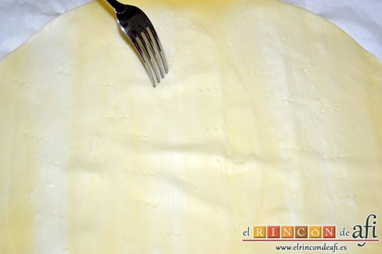 Empanada de crema pastelera o Bugatsa, extender la primera masa de hojaldre sobre una bandeja de horno y pincharla con un tenedor
