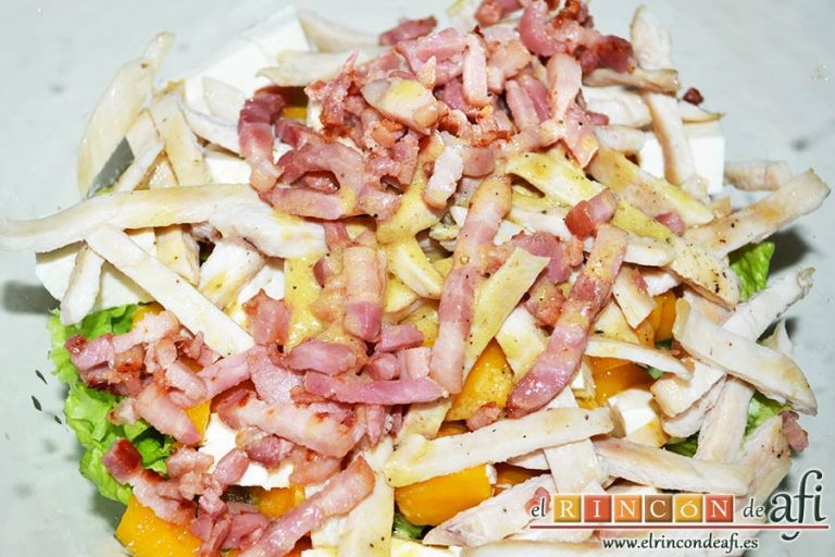 Ensalada con vegetales, pollo, bacon y queso, aliñar la ensalada y mezclar bien