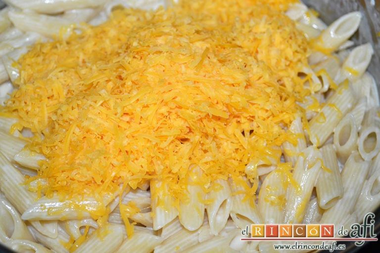 Pasta con ajo y queso Cheddar en una olla, retirar del fuego y añadir el queso Cheddar rallado
