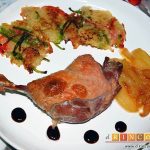 Confit de pato con tortitas de papas con pimientos y peras caramelizadas