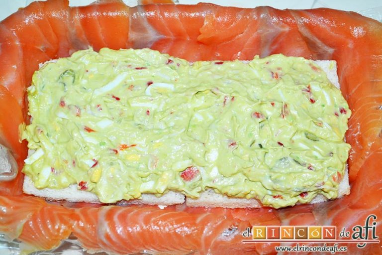 Pastel de salmón marinado, aguacate y pan de molde, colocarlas sobre el salmón por la cara de la mayonesa y luego cubrir la otra cara con parte de la mezcla