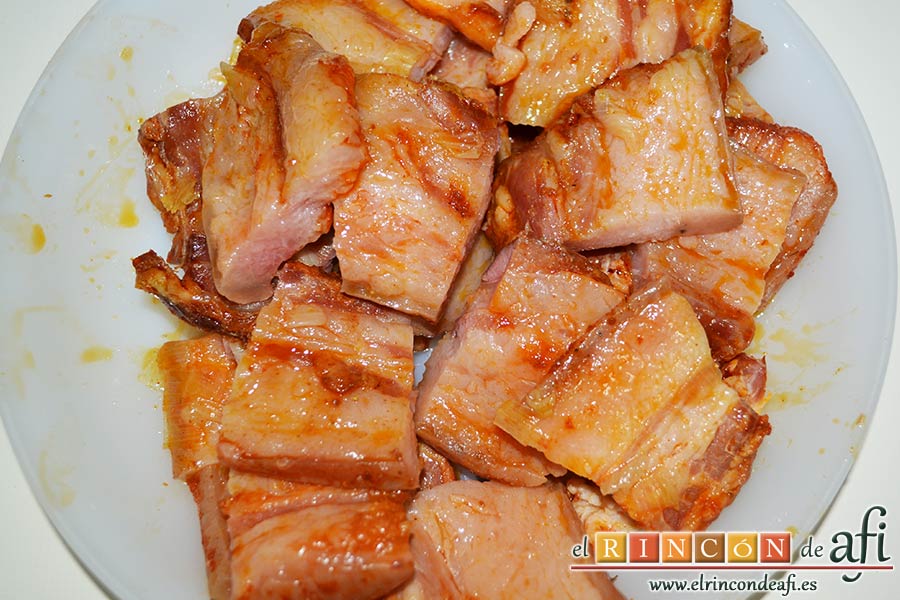 Panceta de cerdo cocida y tostada con puré de papas, cortar la panceta en trozos iguales