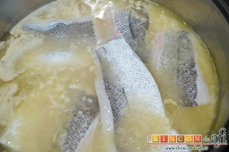 Filetes de merluza en salsa verde con almejas, añadir el pescado con la piel hacia arriba