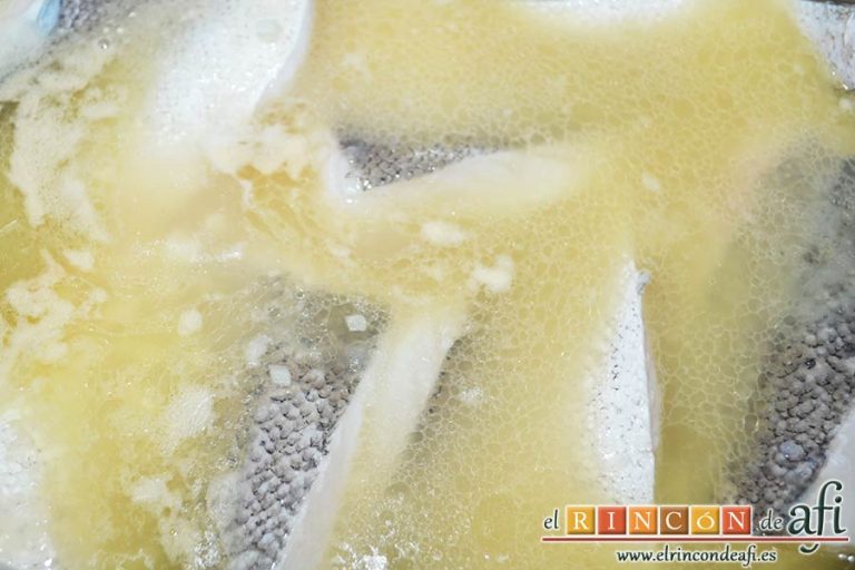 Filetes de merluza en salsa verde con almejas, menear el caldero con cuidado para que el pescado no se rompa