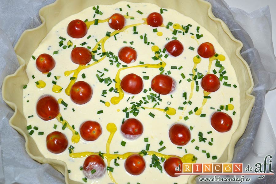Quiche con queso de cabra y tomates cherry, esparcirlos por encima del relleno, añadiendo cebollino fresco picado y aceite de oliva
