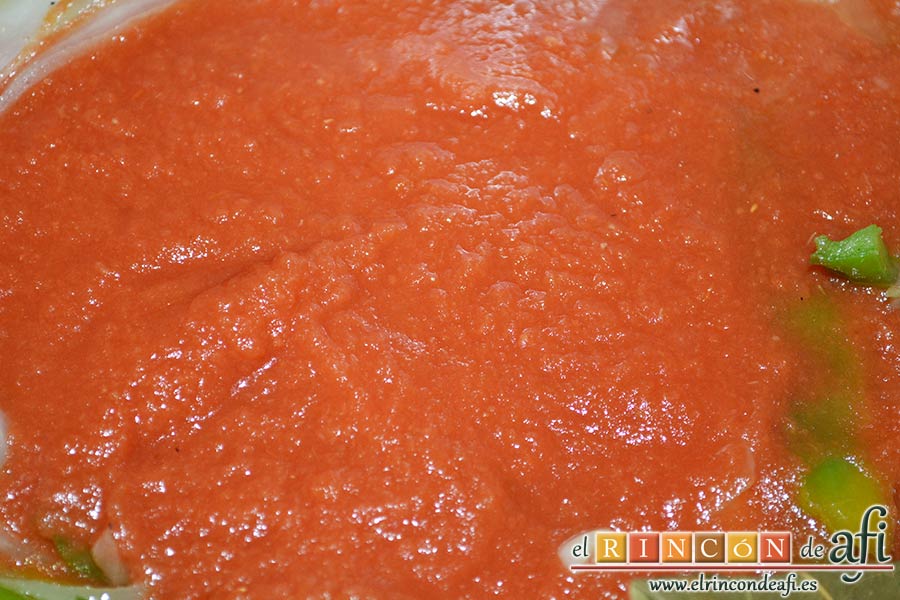 Bacalao en salsa de tomate y pimiento verde, añadir el tomate triturado