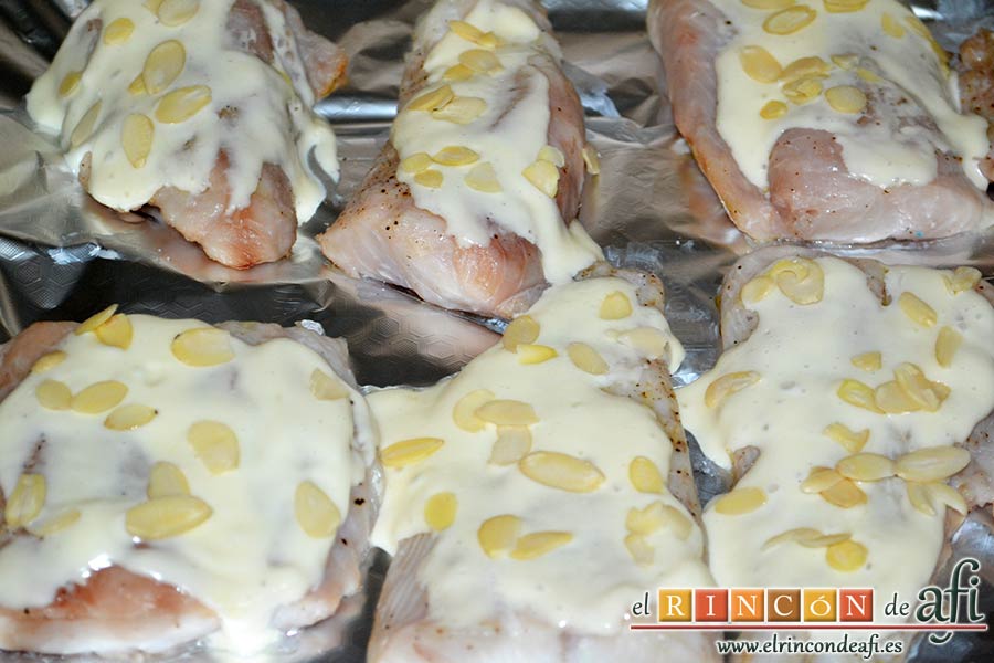 Lomos de merluza glaseados con mayonesa y espárragos trigueros, cubrir de mayonesa y colocar unas almendras laminadas encima