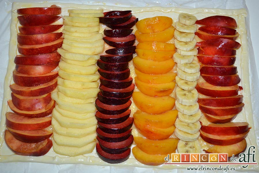Hojaldre con crema pastelera y fruta variada, colocar los gajos de fruta sobre el hojaldre