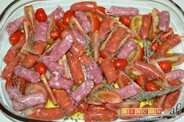Salchichas al horno con tomate y hierbas, trocear las salchichas frescas y colocarlas entre los tomates embadurnando bien