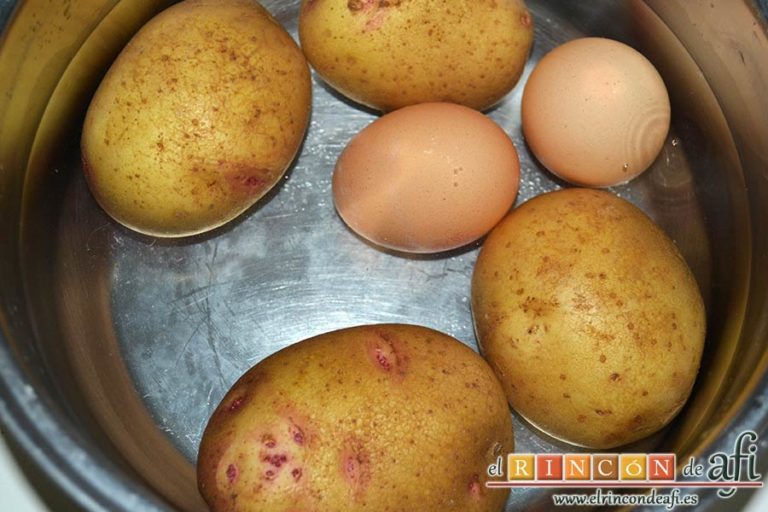 Ensalada de garbanzos, papas, tomates, atún y huevos, cubrir con agua y añadir también los huevos para sancocharlo todo junto