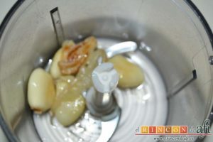 Pollo a la gloria, poner los ajos en un vaso picador con uno poco de cebolla